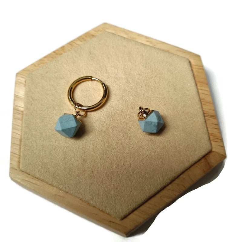 Een paar gouden hoepeloorbellen met blauwe kristallen