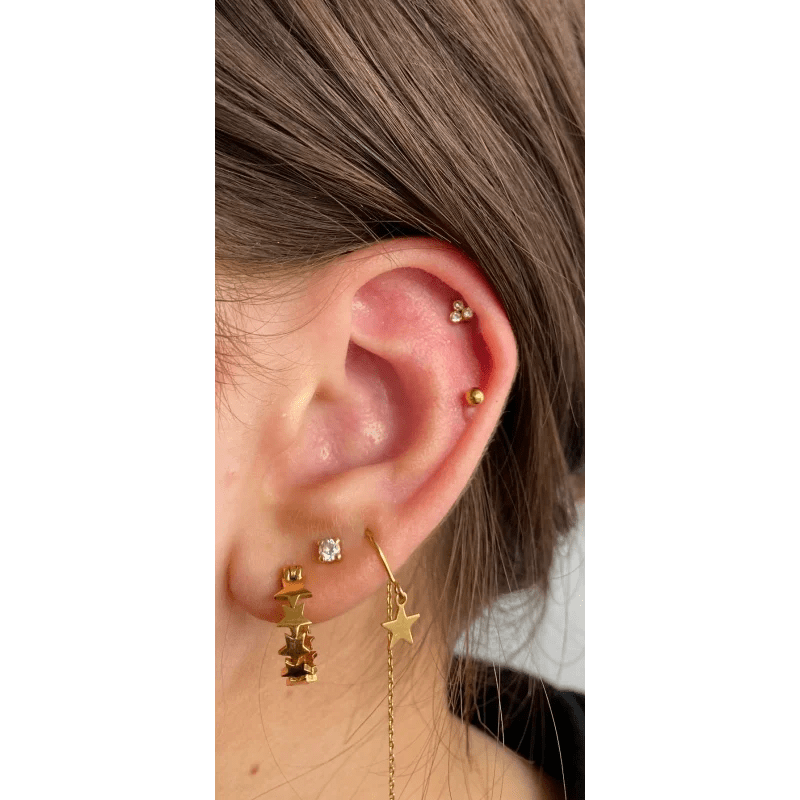 Een vrouw met een gouden ster en maan oorbel