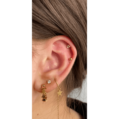 Een vrouw met een gouden ster en maan oorbel