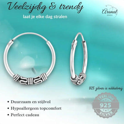 Zilveren hoepel oorbellen met decoratieve kraal.