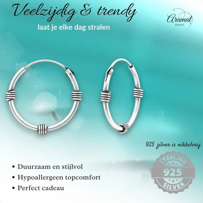 Zilveren hoepeloorbellen met gewikkelde details.