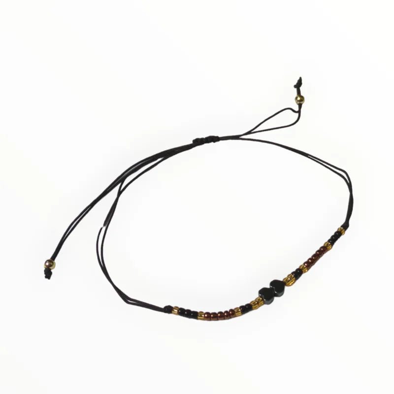 Een armband met een zwart koord en een bruine bea