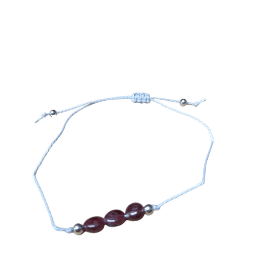 Een armband met een rode glazen bea en een zilveren bea