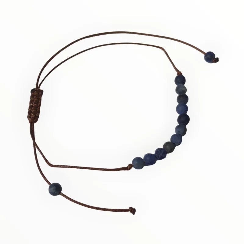 Een armband met blauwe kralen en leren koord