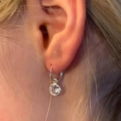 Een vrouw met een zilveren oorpiercing