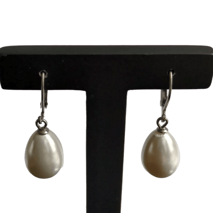 Een paar oorbellen met een witte parel